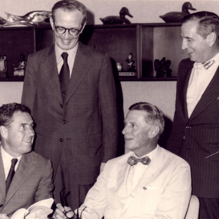 Hospital President Edward J. Roach (standing, left) and Timothy R. Talbot Jr., MD (seated, right), Scientific Director of the Institute for Cancer Research, pictured with other Fox Chase Cancer Center leaders.