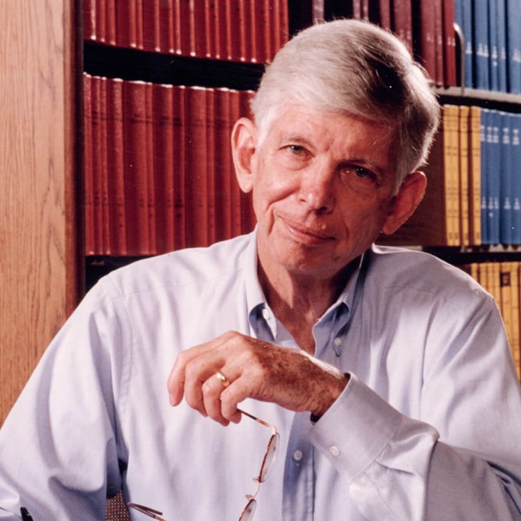 Photo of Alfred Knudson, MD, PhD seated in front of a bookcase.
