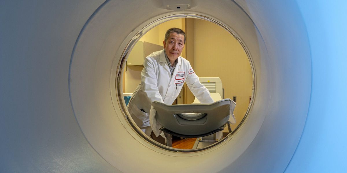 Dr. Yu near PET scan machine.